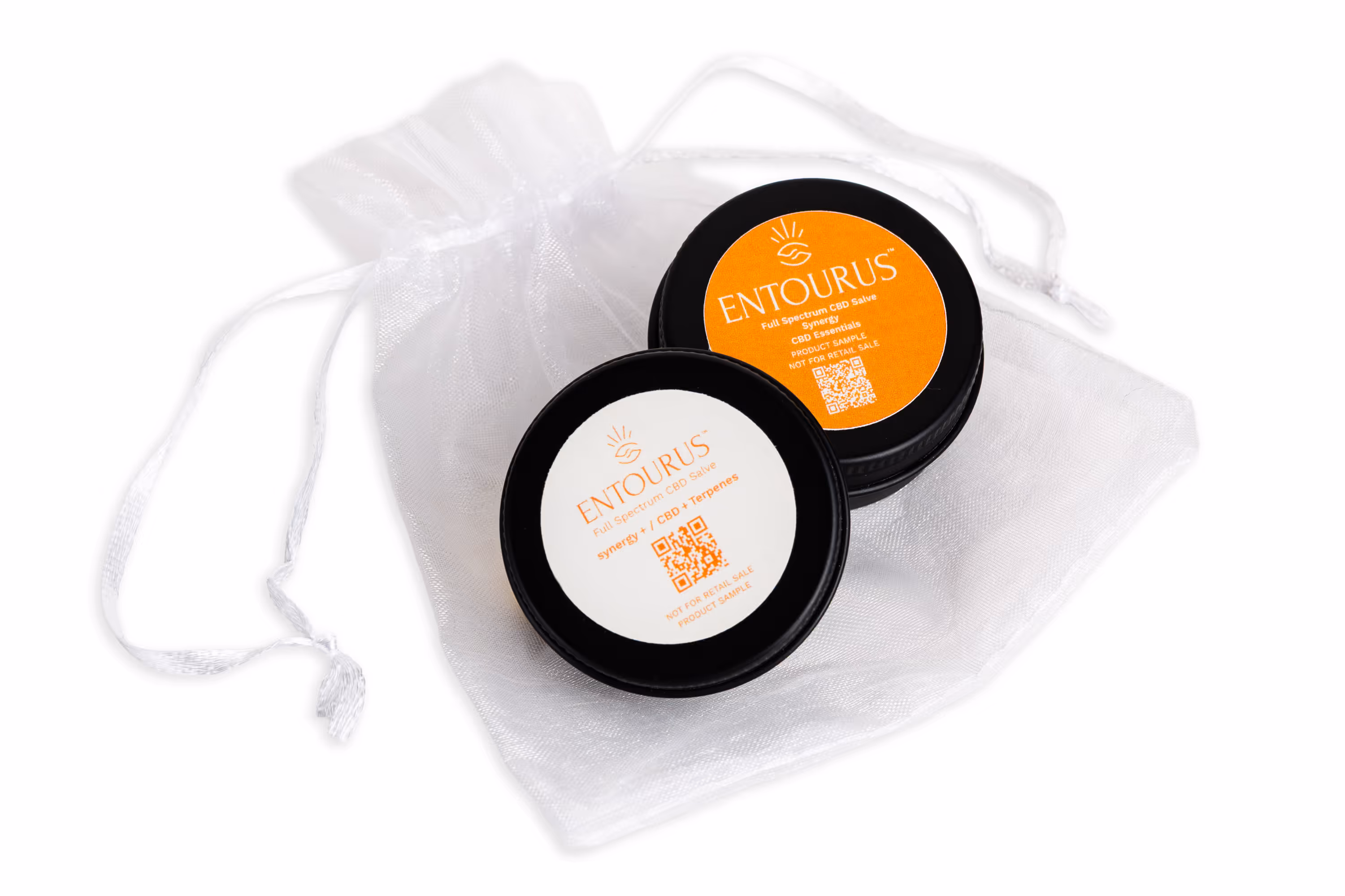 Entourus CBD salve sample tins on white drawstring pouch, orange and white labels, product photography, Photos by Lars.